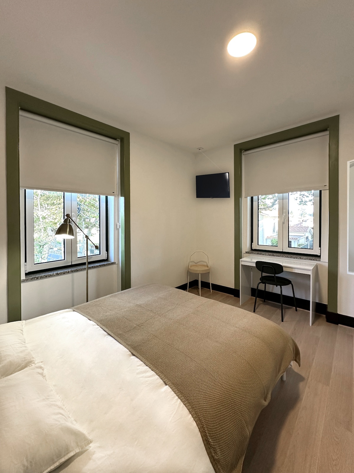 Bedroom with green window trim and workspace