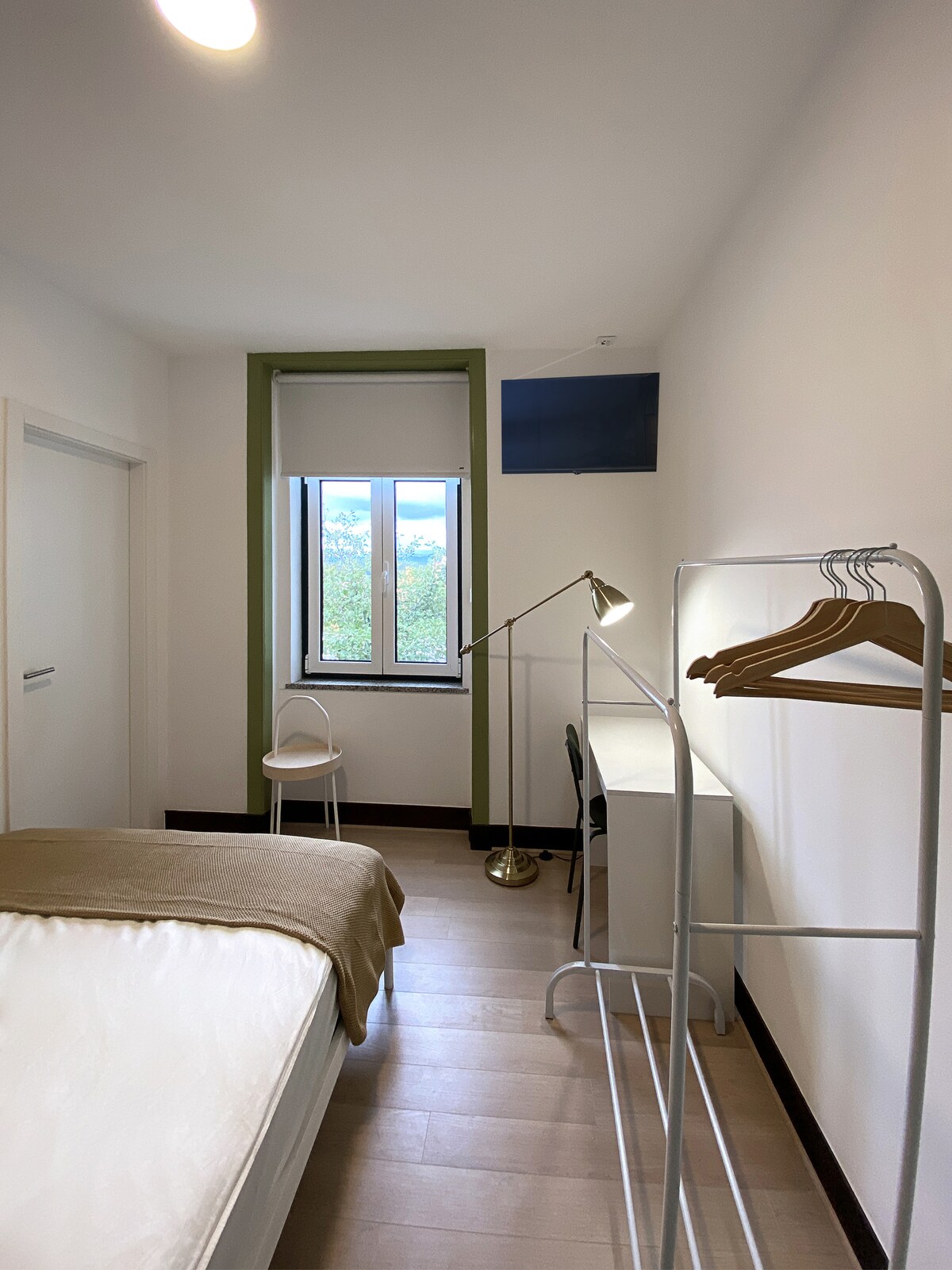 Bedroom with green window trim and hangers