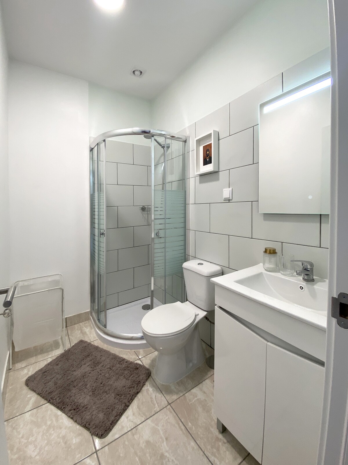 Bathroom with rounded shower and framed art